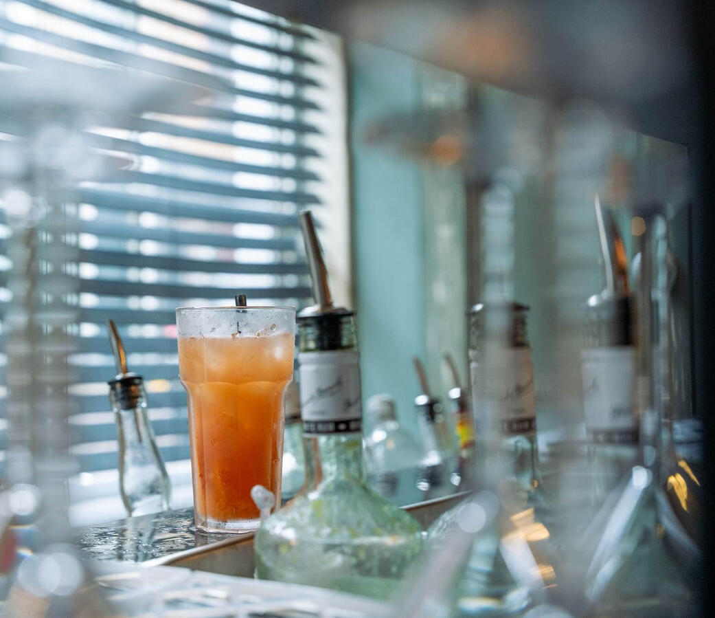 De perfecte afwerking: Verse cocktails met een breed aanbod Vers bereide cocktail op de professionele mobiele bar met diverse flessen op de achtergrond. Kwaliteit en variatie voor jouw evenement in Rotterdam en Zuid-Holland.