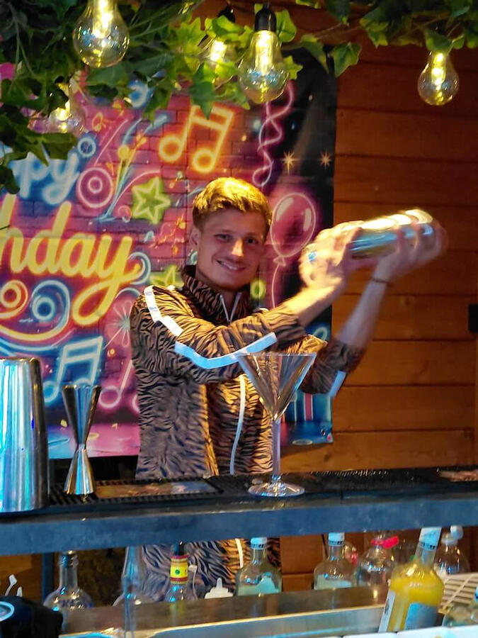 Thema-feest specialist: Jaren 80 disco met verse cocktails Cocktailshaker in retro jaren 80 outfit (fout pak) achter de mobiele bar tijdens een tuinfeest in Rotterdam Noord. Speciale service voor themafeesten en jaren 70/80 partijen in Zuid-Holland.