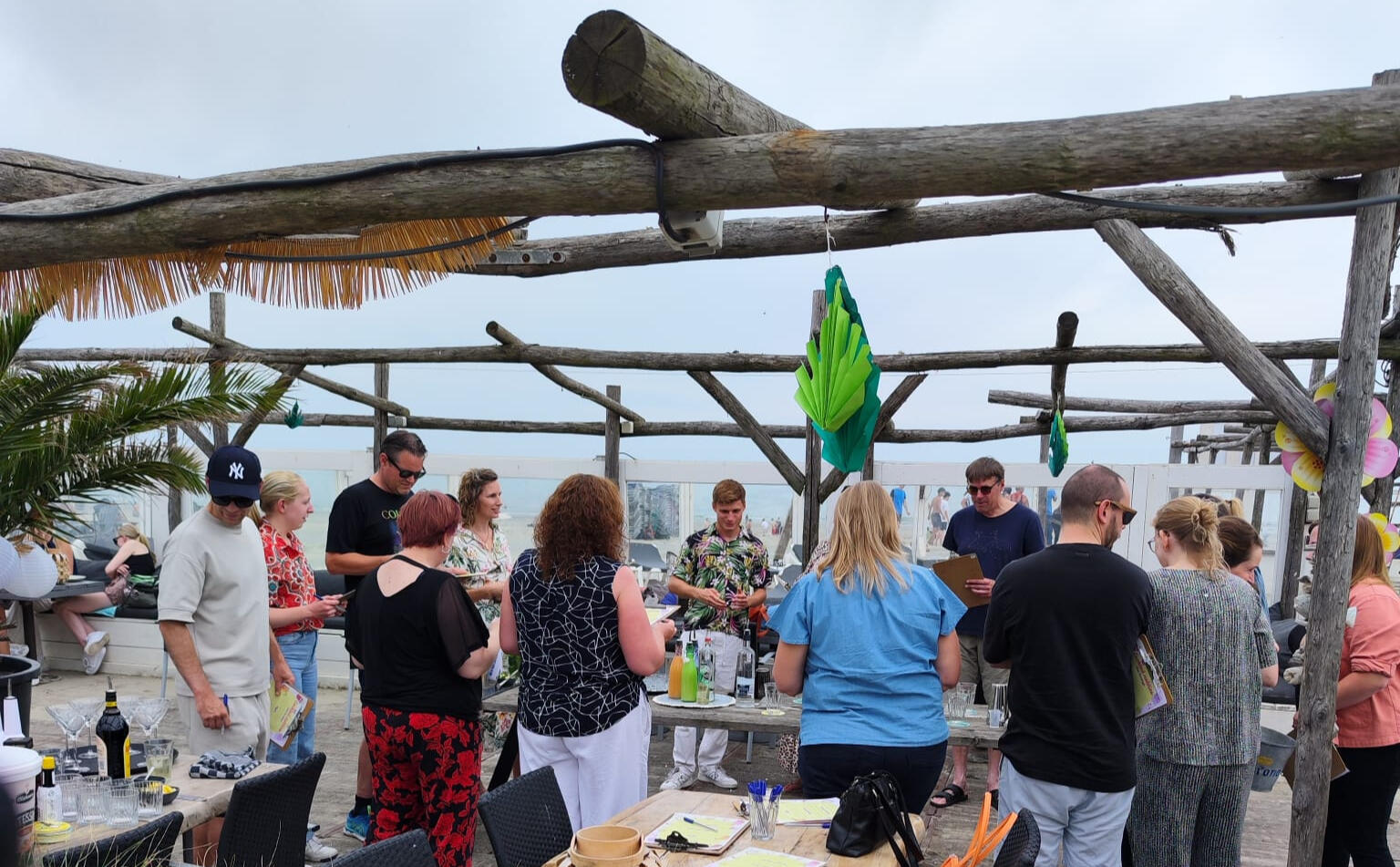 Cocktail workshop op locatie of aan zee Deelnemers leren cocktails shaken tijdens een interactieve workshop van De Cocktail Shaker op het strand van Hoek van Holland.