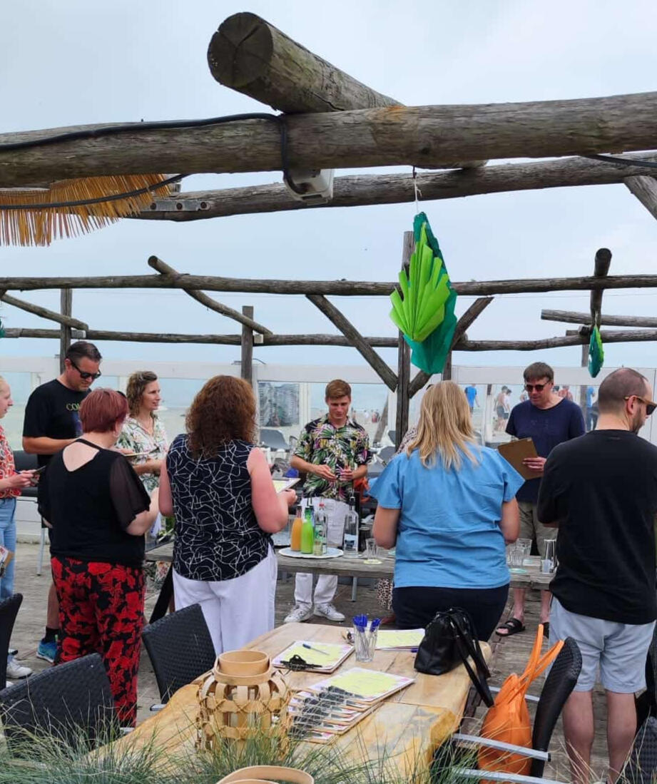 Cocktail workshop op locatie of aan zee Deelnemers leren cocktails shaken tijdens een interactieve workshop van De Cocktail Shaker op het strand van Hoek van Holland.